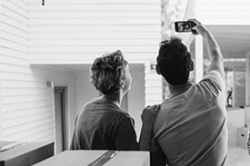 A young couple take a selfie in their new home.