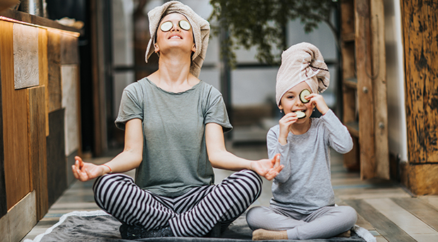 A mother and daughter meditate together.