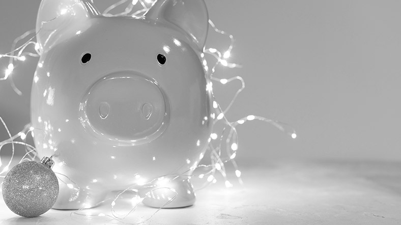 A piggy bank covered with Christmas decorations.