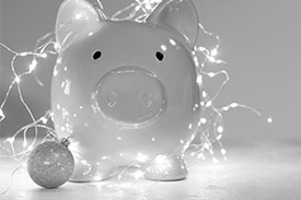 A piggy bank covered with Christmas decorations.