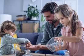 Dad playing with children around coffee table