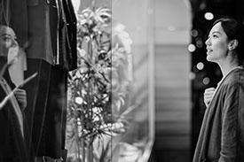 Woman looking in store window and smiling