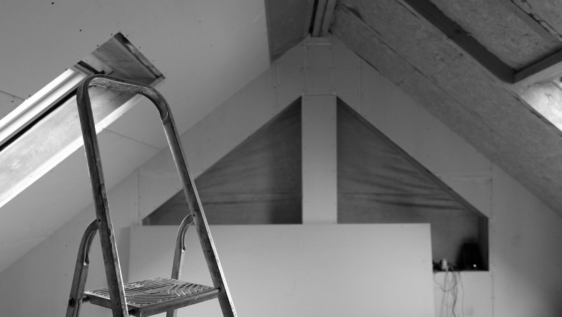 A step ladder is propped against the wall of a freshly painted room