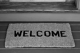 A doormat to a home owner's property reading 'Welcome'.