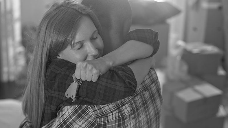 Young couple embracing while moving in to new home