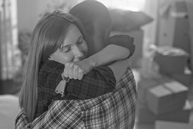 Young couple embracing while moving in to new home