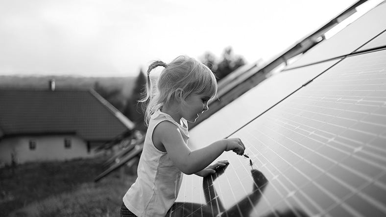 A child looks eagerly at a solar panel grid.
