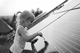 A child looks eagerly at a solar panel grid.